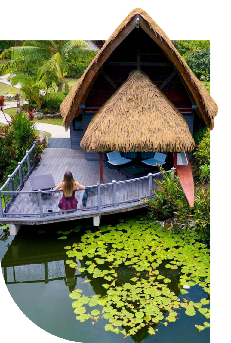 Mujer junto a estanque, bajo techo de cana sintética Palmex.